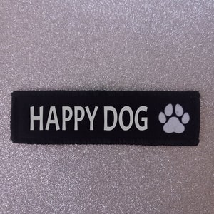 May include: Black fabric patch with white text that reads "HAPPY DOG" and a white paw print.