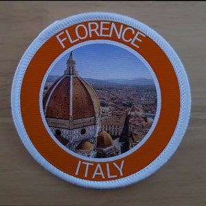 May include: Round patch featuring a detailed image of Florence, Italy, with the Duomo prominently displayed. The patch has an orange border with the words "FLORENCE" and "ITALY" in white lettering. The outer edge is white.