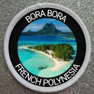 Peut inclure: Écusson rond représentant Bora Bora, Polynésie française. L'image montre un lagon turquoise, des îles verdoyantes et une montagne sous un ciel bleu. L'écusson a une bordure noire avec les mots "BORA BORA" et "POLYNÉSIE FRANÇAISE" en blanc.