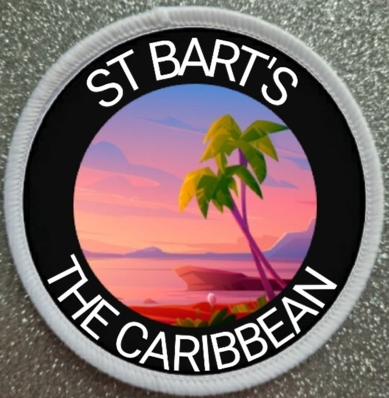 Pode incluir: Um remendo circular branco com texto preto que diz "St. Bart's The Caribbean" em torno de um c&iacute;rculo preto com uma imagem colorida de uma palmeira em uma praia ao p&ocirc;r do sol.