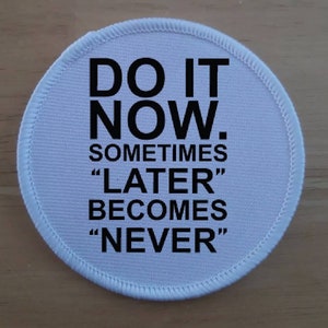 Puede incluir: Parche redondo de tela blanca con texto negro que dice "Do it now. Sometimes "later" becomes "never."