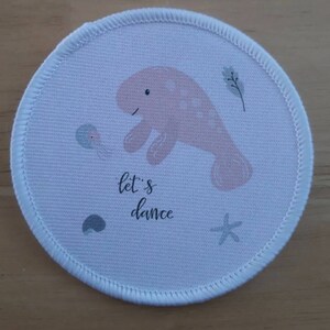 May include: White round fabric patch with a pink manatee, a gray starfish, a gray seashell, and a gray jellyfish. The text "let's dance" is printed in black.