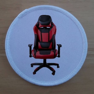 May include: A red and black gaming chair with a headrest and armrests. The chair has a five-star base with wheels.