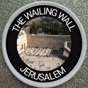 May include: A black and white circular patch with the text "THE WAILING WALL JERUSALEM" around the edge. The centre of the patch features a photograph of the Western Wall in Jerusalem.