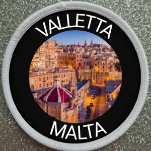 May include: A round, white-bordered patch with a black background. The center features a colorful image of Valletta, Malta, with the text "Valletta" and "Malta" in white.