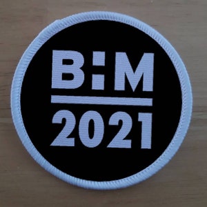 May include: A white and black round patch with the text "B:M 2021" in white.