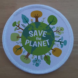 May include: White round fabric patch with a green globe in the centre surrounded by green, yellow, and blue trees. The globe has the text "SAVE the PLANET" on it.