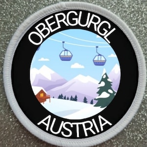 Könnte beinhalten: Ein weißer runder Patch mit schwarzem Rand und den Worten "Obergurgl Österreich" in weißer Schrift. Die Mitte des Patches zeigt ein Cartoon-Bild einer verschneiten Berglandschaft mit einer Hütte, Skiliften und einer Kiefer.
