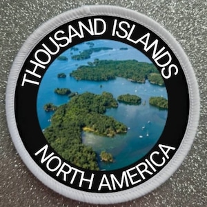 May include: A white and black circular patch with the text "THOUSAND ISLANDS NORTH AMERICA" around a photo of a group of islands in a body of water.