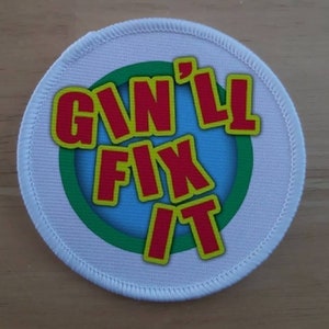 May include: White round fabric patch with a green, blue, and yellow circle design. The text "I'N'LL FIX IT" is in red letters.
