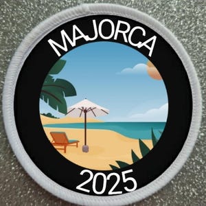 Op de afbeelding: Ronde patch met een zwarte rand en het woord "MAJORCA" in het wit. De patch toont een strandscène met een blauwe lucht, oceaan, palmbomen, een strandstoel en een parasol. Het jaar "2025" staat in het wit onderaan.