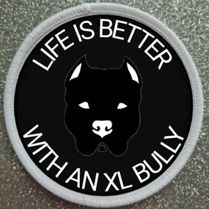 May include: A white and black round patch with the text "Life is better with an XL Bully" and a silhouette of a black dog's head.