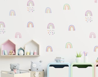 Könnte beinhalten: Eine weiße Wand mit pastellfarbenen Regenbogen-Aufklebern und Herzen. Die Wand ist mit Regalen und Aufbewahrungsboxen dekoriert. Auf den Regalen stehen auch ein paar Spielzeuge.
