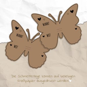 May include: Two brown paper butterfly cutouts with black hearts and the text "WANN?" and "WO?" printed on them. The text is in German.