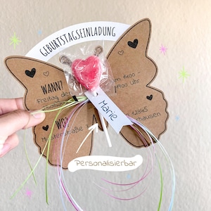 May include: A brown butterfly-shaped card with a lollipop attached to it. The card has the text "Geburtstagseinladung" (Birthday Invitation) and "WANN?" (When?) with a date and time. The card also has the text "WO?" (Where?) with an address. The lollipop is a red heart-shaped lollipop. The card is decorated with hearts and stars. The text "Personalisierbar" (Personalizable) is written on the card.