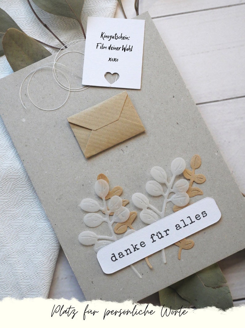 May include: A handmade greeting card with a kraft paper envelope and a small white card with a heart cutout. The card features decorative leaf cutouts and the words "danke f&uuml;r alles".