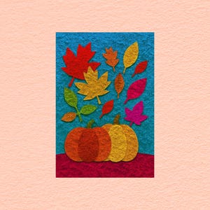 May include: A textured paper collage featuring two pumpkins in orange and yellow hues resting on a dark red ground against a bright blue background, surrounded by various colorful paper leaves in shades of red, yellow, green, orange, and pink.