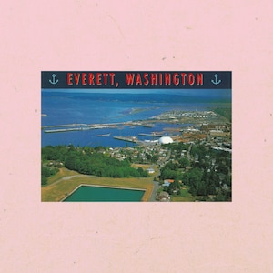 May include: A vintage postcard featuring an aerial view of Everett, Washington, with the city's name in red text at the top. The image shows a body of water, a city, and a green landscape, set against a pink background.
