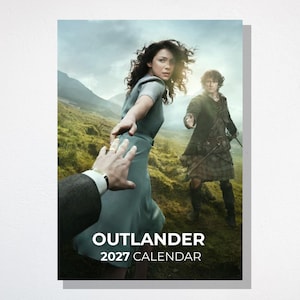 May include: A 2027 Outlander calendar featuring a promotional image of a person in a light blue dress reaching towards a hand, with another person in a dark green jacket and kilt standing nearby in a grassy, mountainous landscape under a cloudy sky.
