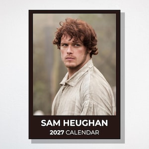 Puede incluir: Un calendario de pared rectangular con un retrato de Sam Heughan de cabello castaño rojizo ondulado, vistiendo una camisa de cuello claro. La sección inferior tiene un borde marrón oscuro con el texto blanco SAM HEUGHAN 2027 CALENDAR.