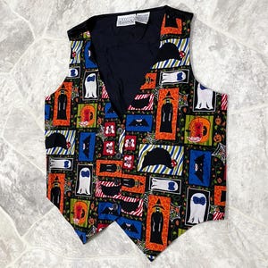 May include: A Halloween-themed vest with a black interior and a colorful exterior pattern. The pattern includes ghosts, bats, jack-o'-lanterns, and witches in rectangular frames. The vest has a V-neck, button closure, and a tailored fit.