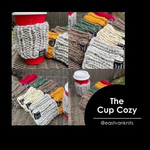 May include: A collection of knitted cup cosies in various colours and patterns, including grey, brown, beige, green, and yellow. The cosies are made with a chunky yarn and have a simple, textured design. The cosies are all labelled with a black tag that reads "East Van Knits". The text "The Cup Cozy" and "@eastvanknits" are also visible in the image.