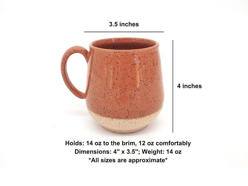 May include: A speckled terracotta-colored ceramic mug with a cream-colored base. The mug has a rounded shape, a large handle, and holds 14 oz to the brim. Dimensions are 4" x 3.5".