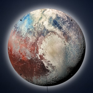 May include: A close-up of a round, three-dimensional, colorful, and textured image of Pluto, a dwarf planet in our solar system. The image is a light brown, red, blue, and white color. The image is lit from the front, creating a halo effect around the edges.