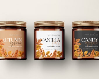 May include: Three glass candle jars with gold lids and labels. The labels feature fall-themed illustrations of leaves and text that reads "Autumn Glow", "Vanilla Fall", and "Candy Apple". Each jar is a soy wax candle with a net weight of 4 oz (113 g) and a burn time of 20 hours.