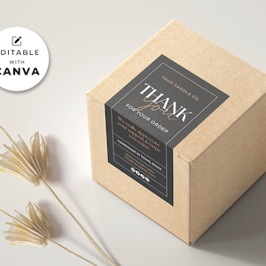 Puede incluir: Una caja de cartón marrón con una etiqueta en blanco y negro que dice "YOUR CANDLE CO. THANK you FOR YOUR ORDER" con un "Gracias" escrito a mano en dorado.