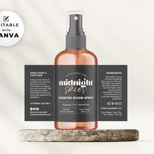 May include: A black and gold label with the text "midnight skies" on a clear glass bottle with a black spray nozzle. The label says "Scented Room Spray" and "Seasalt & Oakmoss".
