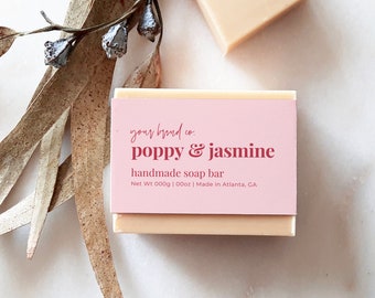 May include: A pink and white soap bar with the text "your brand co. poppy & jasmine handmade soap bar Net Wt 000g | 00oz | Made in Atlanta, GA"