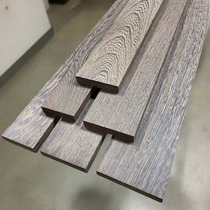 May include: Five pieces of dark brown wood with a striped grain pattern. The wood is arranged in a pyramid shape.