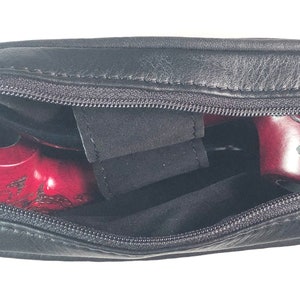 May include: A black leather carrying case with a zipper closure. The case is open and contains two red wooden pipes with intricate designs.