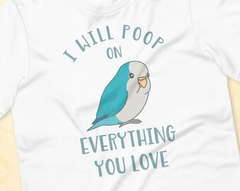 Puede incluir: Camiseta blanca con una ilustración de un pájaro turquesa y azul y el texto "I WILL POOP ON EVERYTHING YOU LOVE". El pájaro tiene un cuerpo azul claro, una cabeza blanca y un pico amarillo. La camiseta es de material suave.