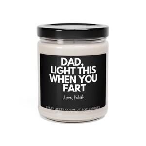 May include: A white candle jar with a black label that reads "DAD, LIGHT THIS WHEN YOU FART Love, Kaleb ESKAY MELTS COCONUT SOY CANDLES".