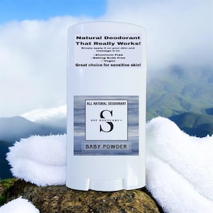May include: A white cylindrical deodorant stick container with a label reading Natural Deodorant That Really Works! Simply apply it on your skin and massage it in! Aluminum Free, Baking Soda Free, Vegan, Great choice for sensitive skin! SAF BODYCARE Baby Powder.