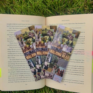 May include: Three colorful bookmarks featuring a collage of images from the TV show "The Walking Dead". The bookmarks are made of paper and have a glossy finish. The text "The Walking Dead" is printed on each bookmark.