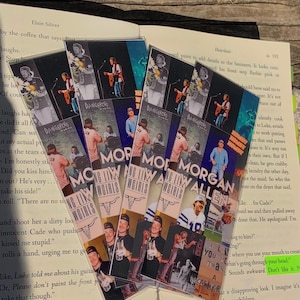 Könnte beinhalten: Ein Set aus sechs bunten Lesezeichen mit einem Musiker mit einer Gitarre und dem Text "Morgan Allen". Die Lesezeichen sind aus stabilem Karton gefertigt und haben verschiedene Designs, darunter eine blau-weiße Gitarre, eine rot-weiße Gitarre und eine schwarz-weiße Gitarre. Die Lesezeichen sind perfekt, um Ihren Platz in Ihrem Lieblingsbuch zu markieren.