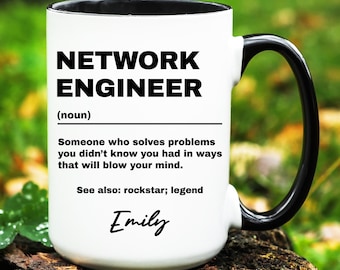 May include: White ceramic mug with a black handle and rim. The mug features the text "NETWORK ENGINEER" in bold black letters, along with a definition and the name "Emily" in a script font. The mug is sitting on a wooden surface.