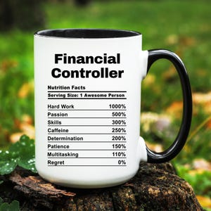May include: A white ceramic mug with a black interior and handle. The mug features the text "Financial Controller" above a "Nutrition Facts" label. The label lists percentages for hard work, passion, skills, caffeine, determination, patience, multitasking, and regret.