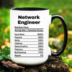 May include: White coffee mug with a black handle. The mug has a black rim and features a graphic of a nutrition facts label for a "Network Engineer". The label lists the percentage of "Hard Work", "Passion", "Skills", "Caffeine", "Determination", "Patience", "Multitasking", and "Regret".
