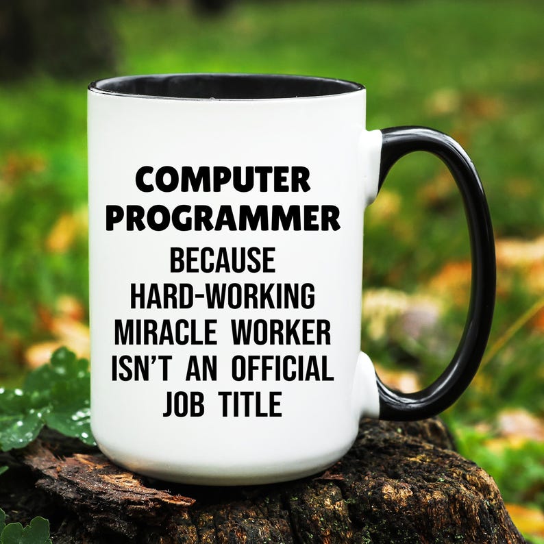 May include: White ceramic mug with a black interior and handle. The mug features the text "COMPUTER PROGRAMMER BECAUSE HARD-WORKING MIRACLE WORKER ISN'T AN OFFICIAL JOB TITLE" in black, bold font.