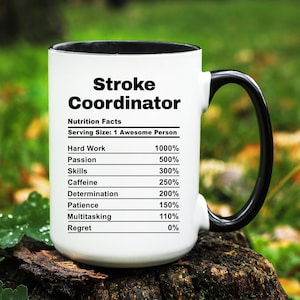 May include: A white ceramic mug with a black interior and handle. The mug features the text "Stroke Coordinator" above a "Nutrition Facts" label. The label lists percentages for hard work, passion, skills, caffeine, determination, patience, multitasking, and regret.