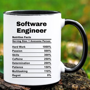 May include: A white ceramic mug with a black interior and handle. The mug features the text "Software Engineer" and a "Nutrition Facts" label listing percentages for hard work, passion, skills, caffeine, determination, patience, multitasking, and regret.