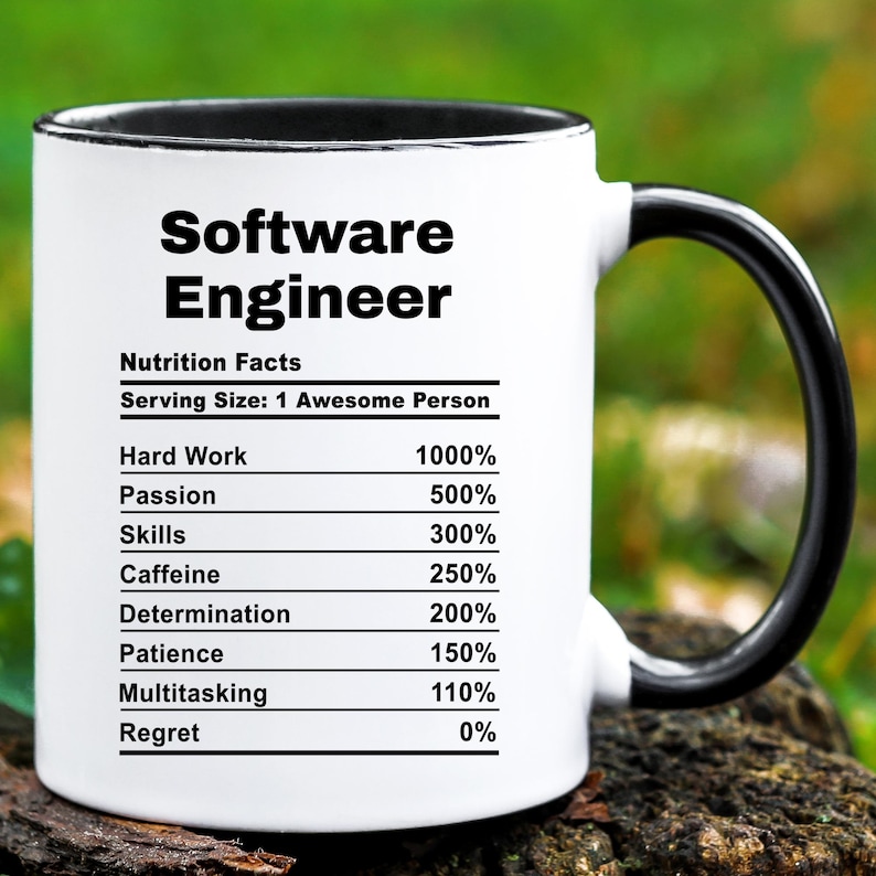 May include: A white ceramic mug with a black interior and handle. The mug features the text "Software Engineer" and a "Nutrition Facts" label listing percentages for hard work, passion, skills, caffeine, determination, patience, multitasking, and regret.