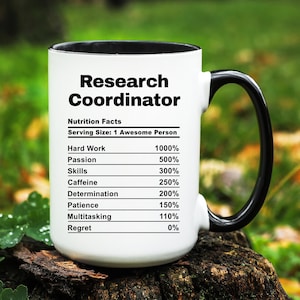 May include: White ceramic mug with a black interior and handle. The mug features the text "Research Coordinator" above a "Nutrition Facts" label. The label lists percentages for hard work, passion, skills, caffeine, determination, patience, multitasking, and regret.
