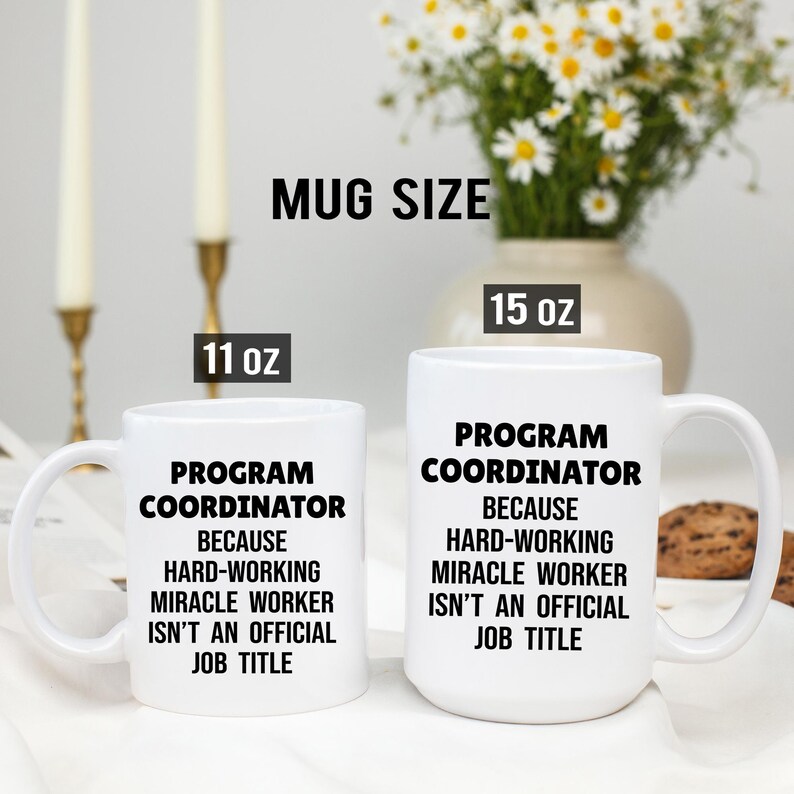 May include: Two white ceramic mugs with black text that reads "PROGRAM COORDINATOR BECAUSE HARD-WORKING MIRACLE WORKER ISN'T AN OFFICIAL JOB TITLE." One mug is 11 oz, the other is 15 oz. A vase of flowers is in the background.