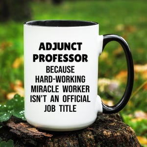 May include: White ceramic mug with a black interior and handle. The mug features the text "ADJUNCT PROFESSOR BECAUSE HARD-WORKING MIRACLE WORKER ISN'T AN OFFICIAL JOB TITLE" in black, bold font.