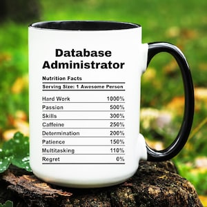 May include: White ceramic mug with a black handle and rim. The mug features the text "Database Administrator" and a "Nutrition Facts" label listing percentages for hard work, passion, skills, caffeine, determination, patience, multitasking, and regret.